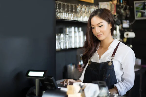 Азіатські жінки Barista посміхається і за допомогою кавомашину в s кави — стокове фото