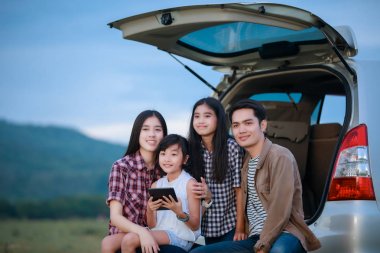 enjo için arabada oturan Asya ailesi ile mutlu küçük kız