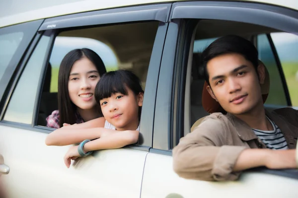 Lycklig liten flicka med asiatisk familj sitter i bilen för enjo — Stockfoto