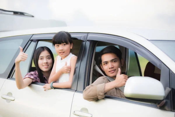 Heureuse petite fille avec asiatique famille assis dans la voiture pour enjo — Photo