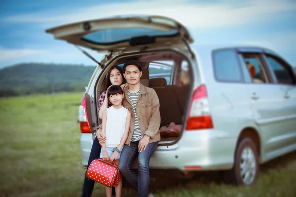 Lycklig liten flicka med asiatisk familj sitter i bilen för enjo — Stockfoto