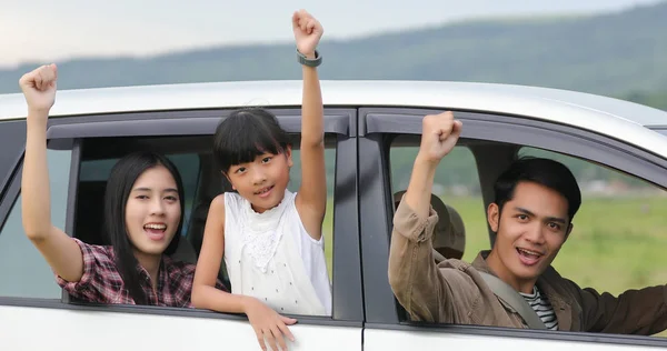 Happy little girl  with asian family sitting in the car for enjo