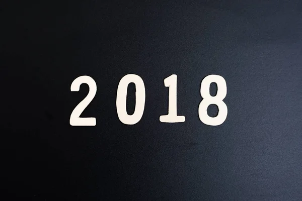 Mot en bois des numéros 2018 se trouvent sur la table en bois et backgrou noir — Photo