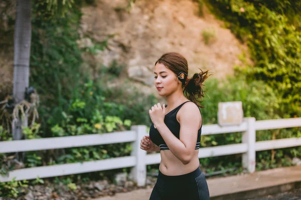 Asiatiska kvinnor löpning och jogging under utomhus på road i park — Stockfoto