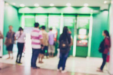 İnsanlar stand ATM Para çekmek için sırada bulanık 