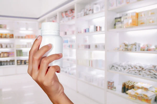 Mão de médico segurando frasco de medicina no armário de medicina e s — Fotografia de Stock