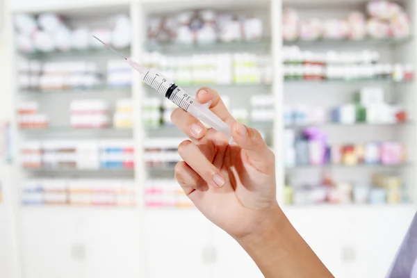 Manos a los médicos llenando una jeringa en la tienda de medicamentos y medicamentos — Foto de Stock