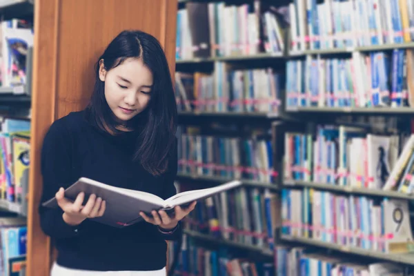 Estudantes asiáticos lendo livros na biblioteca . — Fotografia de Stock