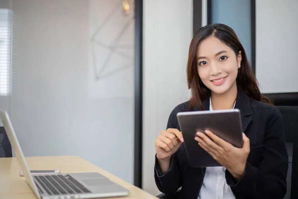 Asiático mulheres de negócios usando tablet para trabalhar no escritório relaxar t — Fotografia de Stock