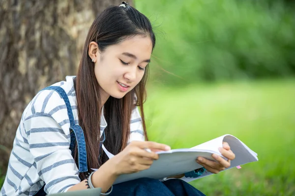 Hermosa chica asiática estudiante sosteniendo libros y sonriendo a la cámara —  Fotos de Stock