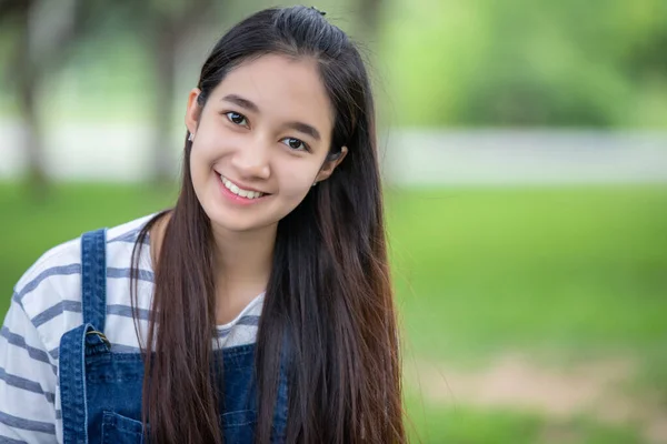Lächelnd schöne asiatische Mädchen am Baum im Park im Sommer zum Entspannen — Stockfoto