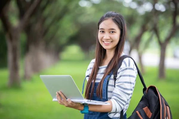 Krásná Asiatka student drží knihy a usmívá se na kameru — Stock fotografie
