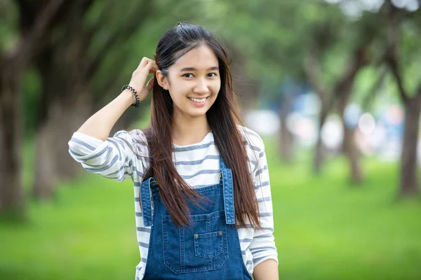 Sorrindo bela menina asiática na árvore no parque no verão para relaxar — Fotografia de Stock