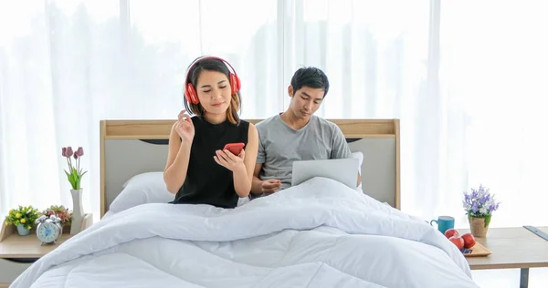 Asiático pareja amantes escuchando música y cantando en su cama un — Foto de Stock