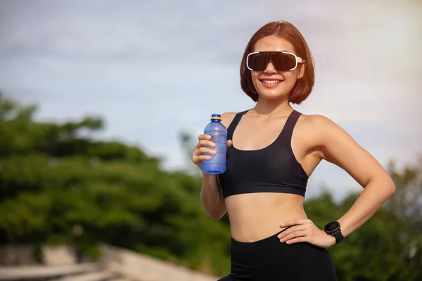 Sportig kvinna asiatisk dricksvatten utomhus efter att ha kört på sunn — Stockfoto