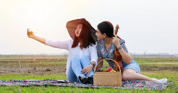 Skupina asijských přátel, kteří hrají ukelele a tráví čas nedáváš — Stock fotografie