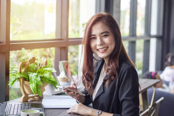 Mujeres de negocios asiáticas usando notebook y teléfono inteligente y negocios —  Fotos de Stock