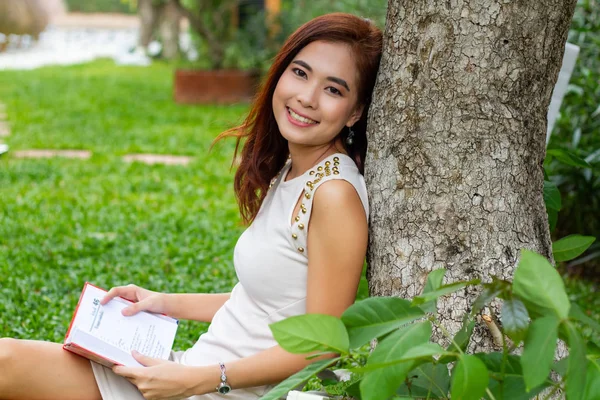 Mujer asiática leyendo un libro en el jardín para relajarse —  Fotos de Stock