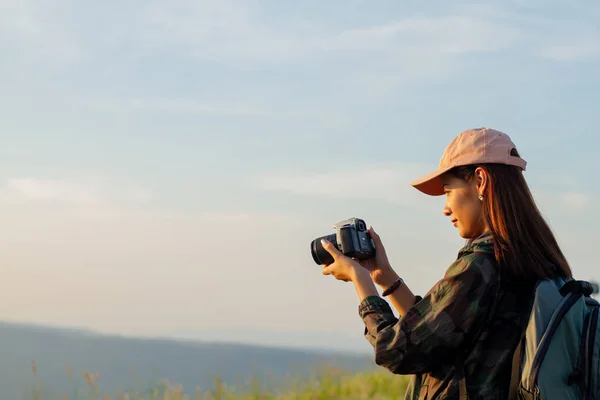 Ženy asijské s batohem pořízení fotografie na pohled na východ slunce moře — Stock fotografie