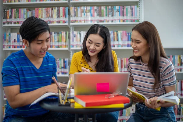 Группа азиатских студентов Улыбайтесь и читайте книги и с помощью ноутбука — стоковое фото