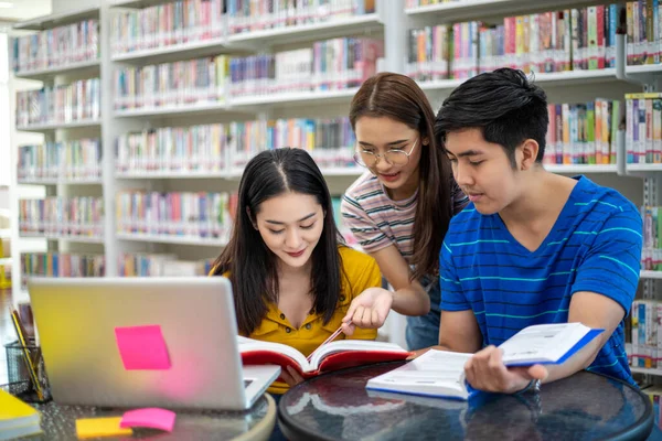 Grupo de estudiantes asiáticos Sonreír y leer libro y el uso de notebook — Foto de Stock