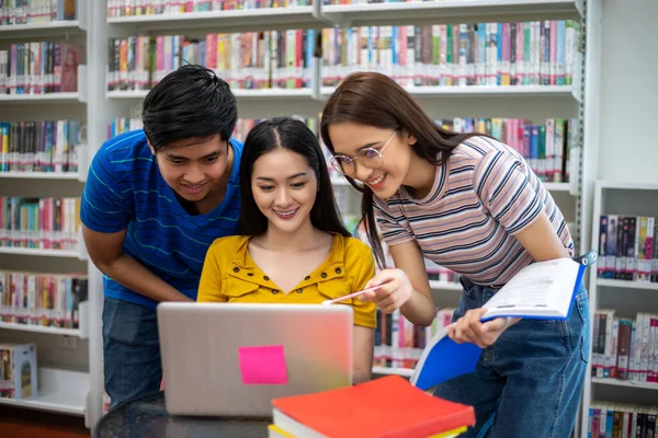 Grup Asyalı Öğrenciler Gülümseyin, kitap okuyun ve defter kullanın 