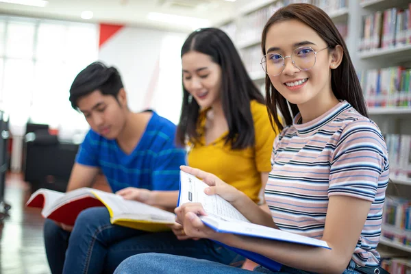 Grupo Estudantes Asiáticos Sorrir e ler livro e usando notebook — Fotografia de Stock