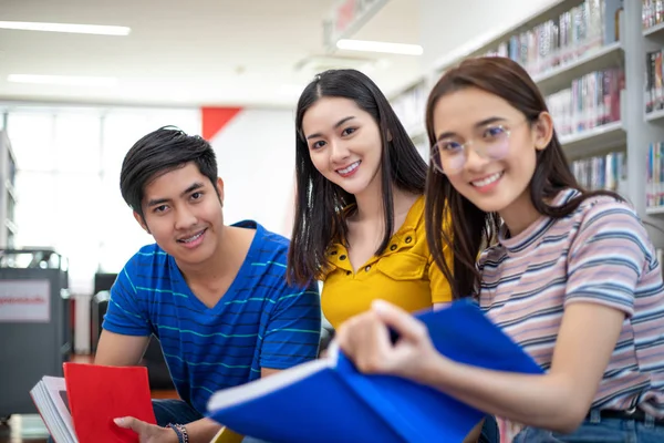 Grupo de estudiantes asiáticos Sonreír y leer libro y el uso de notebook — Foto de Stock