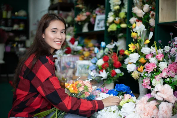 Gülümseyen Kadın Çiçekçi Küçük Işletme Sahibi Çiçekçide Çiçekleri Inceleyen Genç — Stok fotoğraf
