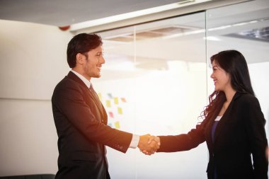 El sıkışan ve sözleşme ve bir buluşma bitirme imzalamak için onların anlaşma gülümseyen iş adamları 