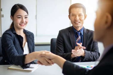 El sıkışan ve sözleşme ve bir buluşma bitirme imzalamak için onların anlaşma gülümseyen iş adamları 