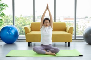 Asyalı kadın yoga evde egzersiz yapıyor.  