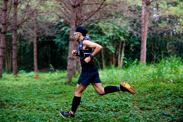 森の中を走るトレイルのスポーツシューズを履いたトレイルとアスリートの足の男ランナー — ストック写真