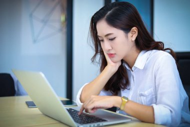 Asyalı iş kadınları defter ve ciddi ve baş ağrısı kullanıyor. 