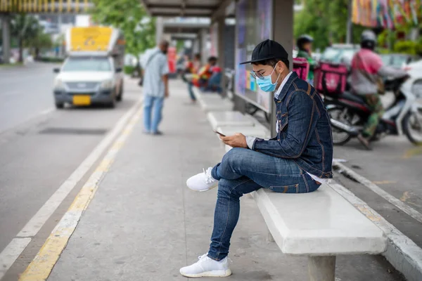 亚洲年轻人在城市里使用智能手机 戴口罩保护空气污染 颗粒物和流感病毒 角斗士 — 图库照片