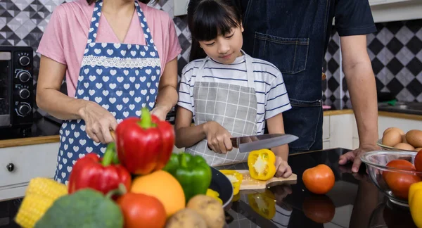 Asian families are cooking  and parents are teaching their daughters to cook in the kitchen at home.