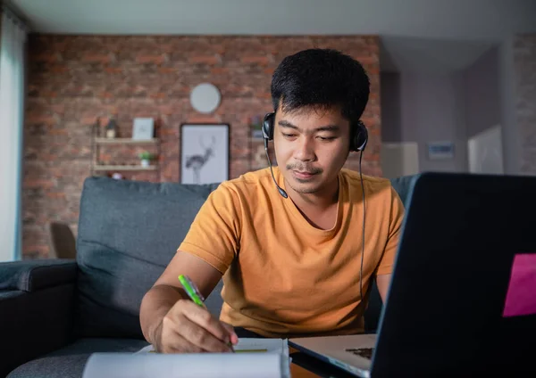 아시아 사업가들은 노트북 컴퓨터를 사용하고 온라인 회의를 헤드폰을 집에서 일하고 — 스톡 사진