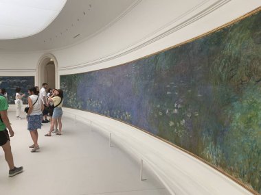 Paris, Fransa - 25 Temmuz 2019: İzlenimci ressam Claude Monet Water Lilies 'in Paris Orangerie Müzesi' ndeki (Mus? e de l 'Orangerie) dev tablolarına hayranlar. Yatay çekim