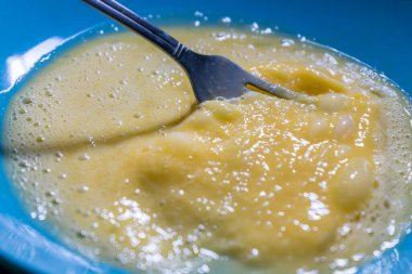 Ev yapımı hamur işleri için tabakta çatalla çırpılmış yumurta..