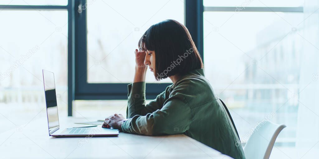 Side view of concentrated at work confident young woman