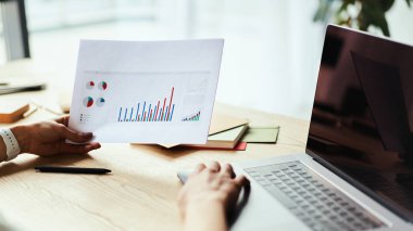 Kağıt grafik çizelgesi ve daktilo tutan kadın