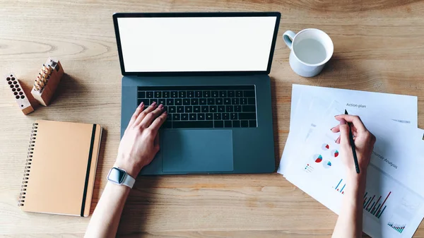 Ovanifrån av kvinna händer skriva på laptop tangentbord och analysera grafik — Stockfoto