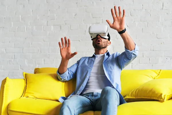 Front view of man wearing glasses of virtual reality, surprised expression — Stockfoto