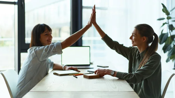 Side view of happy businesswomen giving high five in office after meeting — Stock Photo, Image