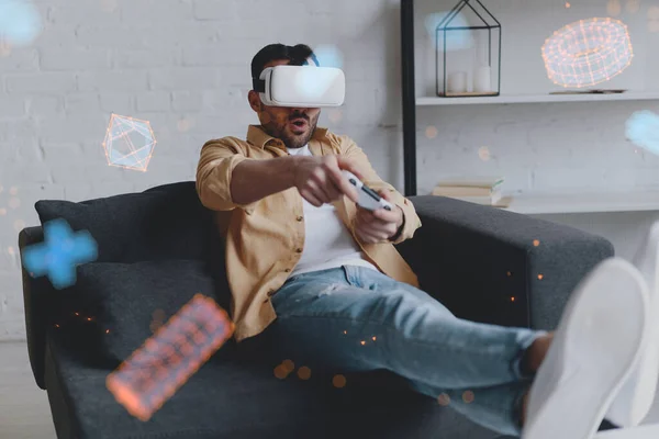 Young smiling man in VR glasses playing game using joystick, virtual reality — Stockfoto