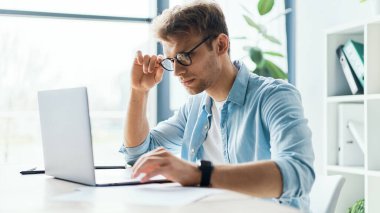 Side view of concentrated at work confident young woman in glasses