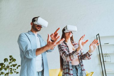 Genç mutlu çift, VR gözlükleriyle eğleniyor..