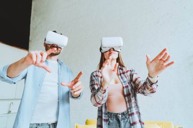 Genç mutlu çift, VR gözlükleriyle eğleniyor.