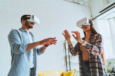 Genç mutlu çift, VR gözlükleriyle eğleniyor.