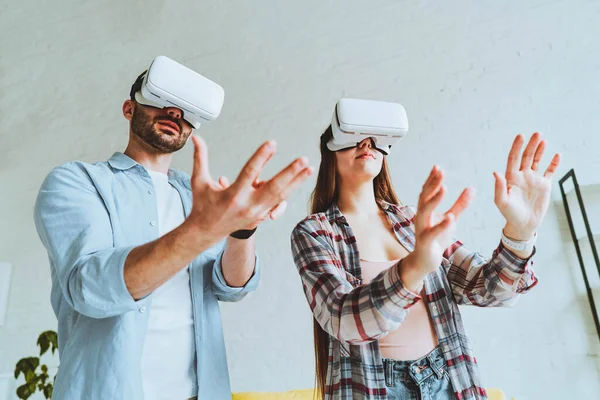 Genç mutlu çift, VR gözlükleriyle eğleniyor.